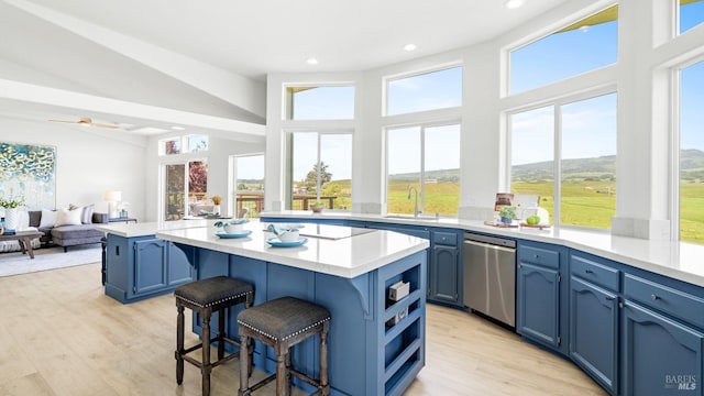 kitchen featuring a kitchen breakfast bar, blue cabinetry, dishwasher, and a sink