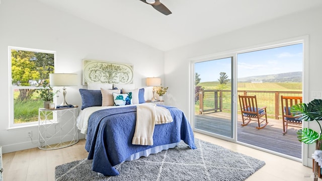 bedroom featuring multiple windows, access to outside, and lofted ceiling