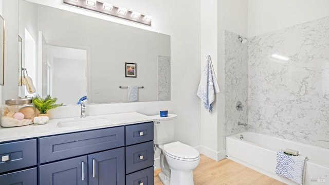 full bathroom with toilet, washtub / shower combination, wood finished floors, and vanity