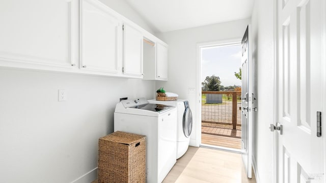 laundry room with light wood-style floors, baseboards, washer and dryer, and cabinet space