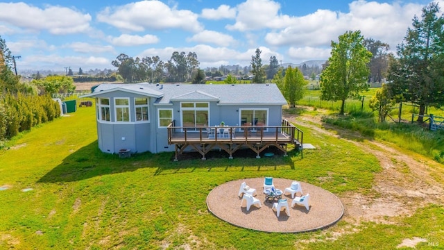 back of property with curved driveway, a deck with mountain view, and a yard