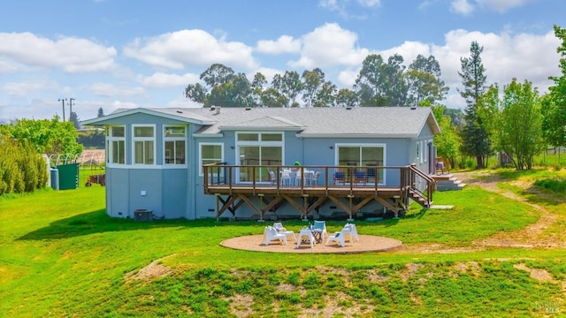 back of property with a deck, a patio, stucco siding, and a yard