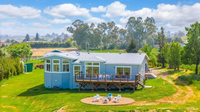 rear view of property featuring a lawn, a patio, and a wooden deck