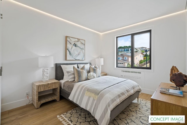 bedroom with light wood finished floors and baseboards