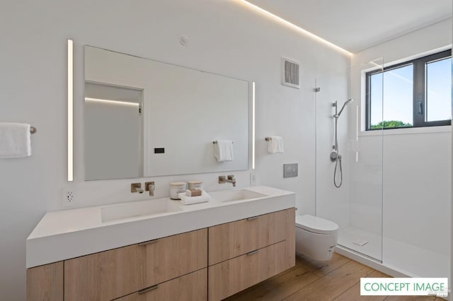 full bathroom featuring a sink, double vanity, visible vents, toilet, and a walk in shower