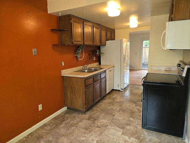 kitchen with white appliances, open shelves, light countertops, a sink, and baseboards