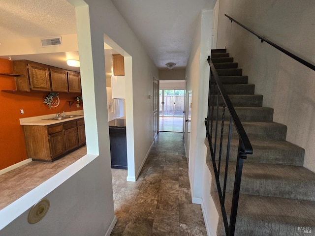 stairway featuring baseboards, visible vents, and stone finish flooring