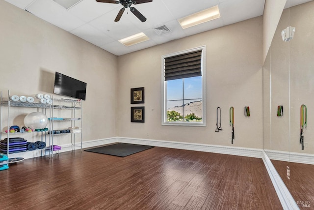 workout room with baseboards, visible vents, wood finished floors, and ceiling fan