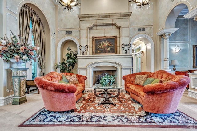 sitting room featuring an inviting chandelier, a towering ceiling, visible vents, and a high end fireplace