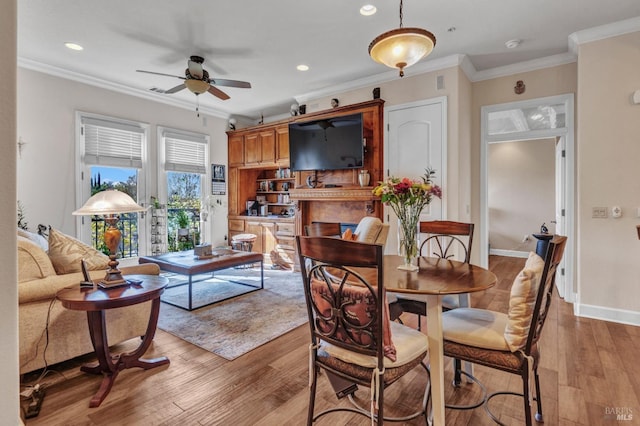 dining room featuring crown molding, recessed lighting, a ceiling fan, and light wood-style flooring