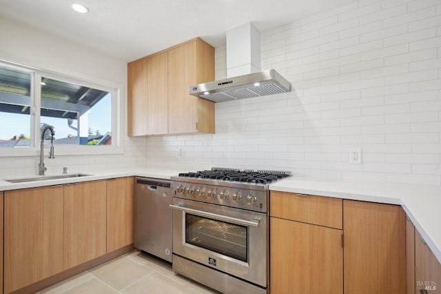 kitchen featuring stainless steel appliances, light countertops, backsplash, a sink, and wall chimney exhaust hood