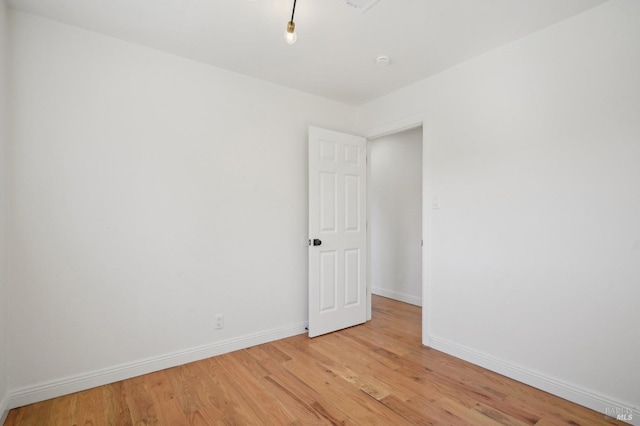 empty room with light wood-type flooring and baseboards