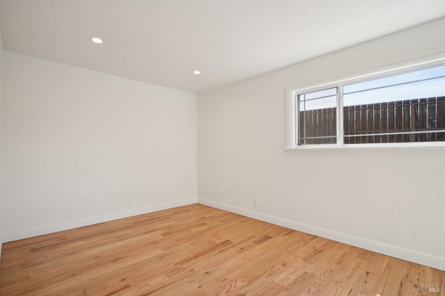 unfurnished room featuring light wood-style floors, recessed lighting, and baseboards