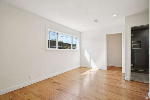 unfurnished room with baseboards, light wood-type flooring, visible vents, and recessed lighting