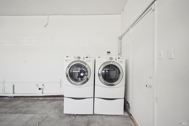 clothes washing area with washing machine and clothes dryer and laundry area
