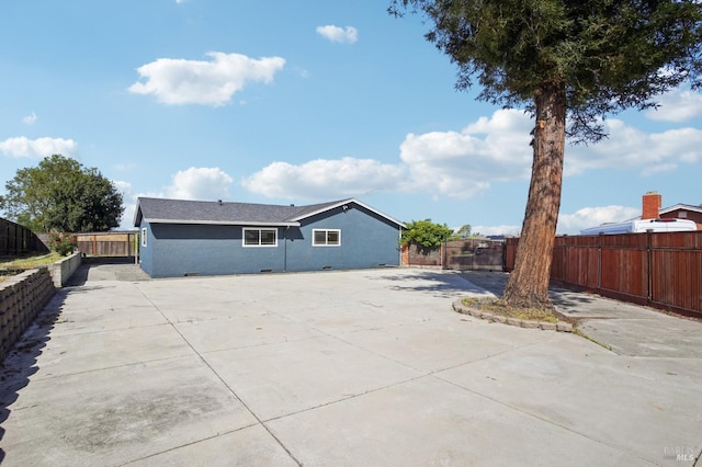 rear view of property featuring a patio and a fenced backyard