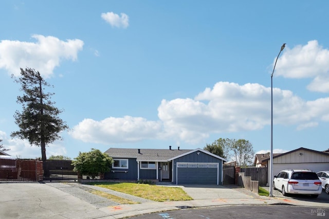 ranch-style home featuring driveway, an attached garage, a gate, and fence