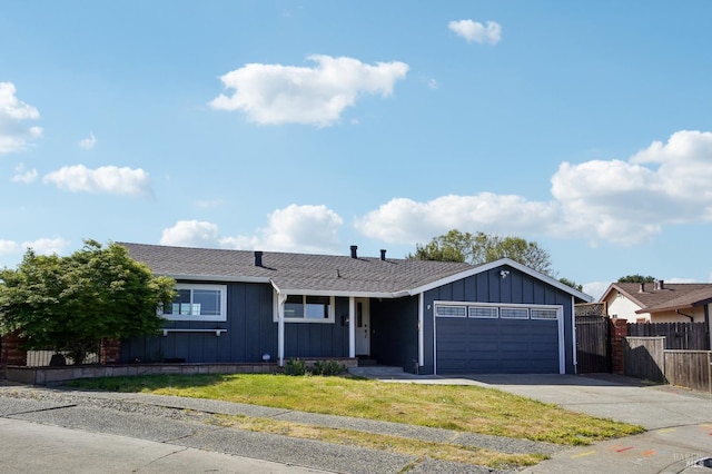 ranch-style house with board and batten siding, concrete driveway, a front yard, fence, and a garage