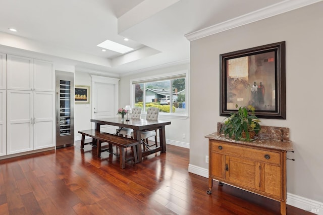 dining room with recessed lighting, a raised ceiling, dark wood-type flooring, baseboards, and a skylight