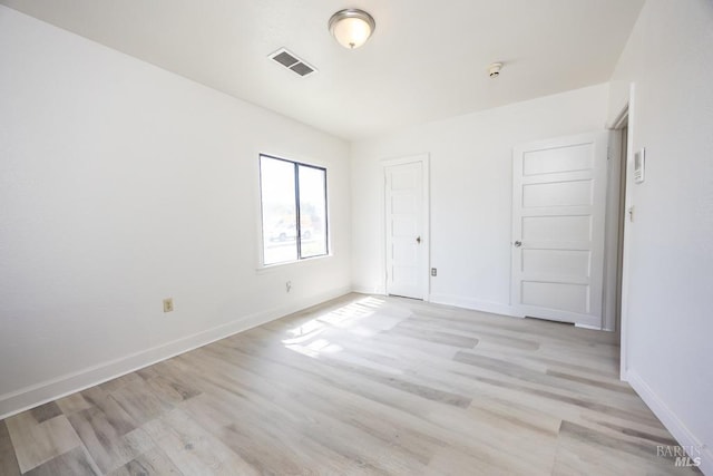 unfurnished bedroom with visible vents, baseboards, and light wood-type flooring