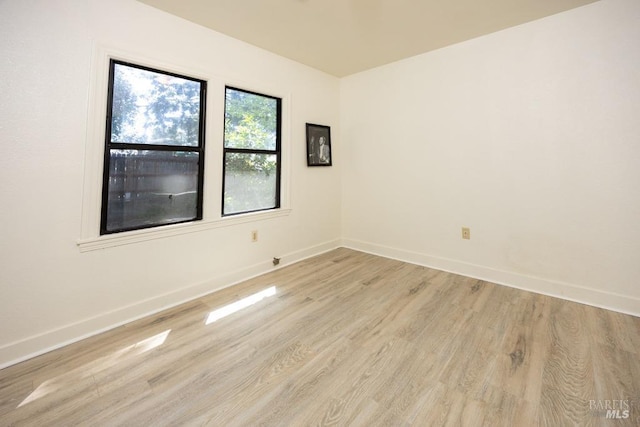 unfurnished room featuring light wood-style flooring and baseboards