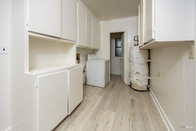 laundry area featuring cabinet space, water heater, light wood-style floors, and washer / clothes dryer