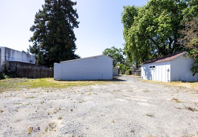 view of yard featuring fence and an outbuilding