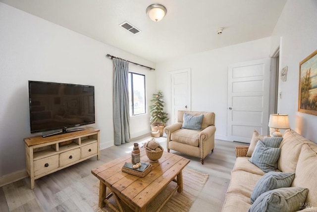 living area with visible vents, light wood finished floors, and baseboards
