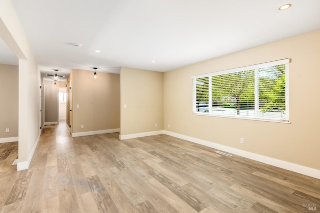 unfurnished room featuring recessed lighting, light wood finished floors, visible vents, and baseboards