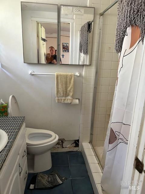 full bathroom with toilet, a stall shower, tile patterned floors, and vanity