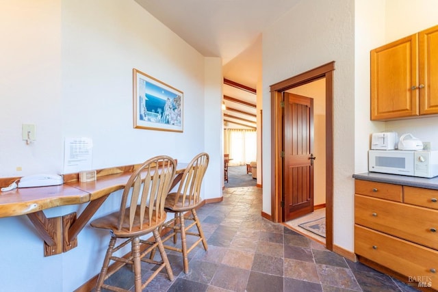 dining area featuring stone finish flooring and baseboards
