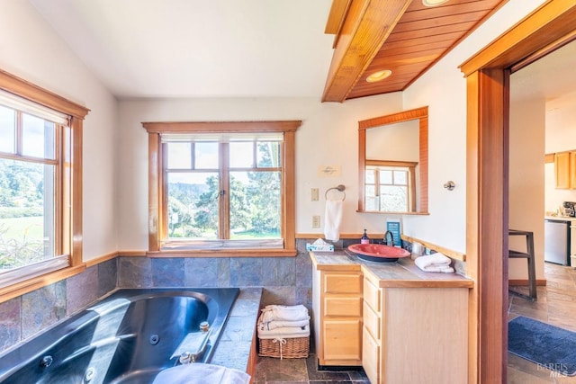 full bath with a healthy amount of sunlight, vanity, and a whirlpool tub