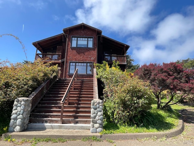 back of house featuring stairs and a balcony