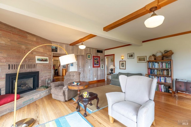 living room with beamed ceiling, wood finished floors, and a fireplace
