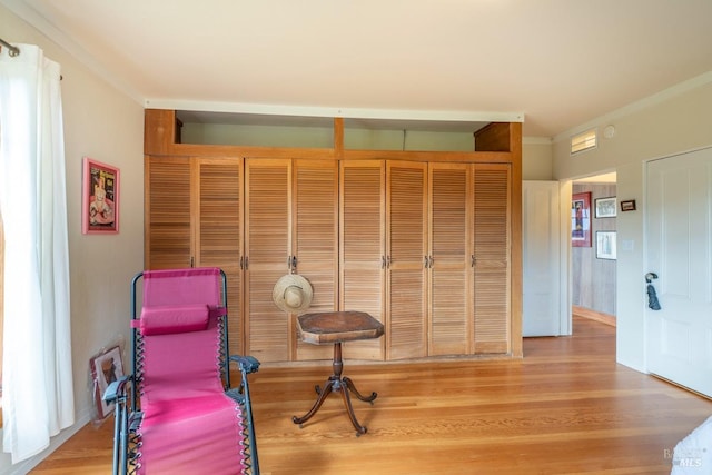 unfurnished room with ornamental molding and wood finished floors