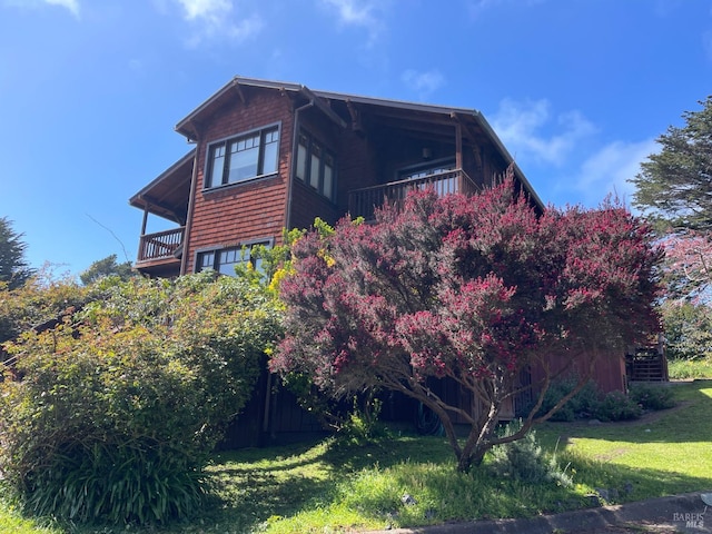 view of property exterior with a balcony and a yard
