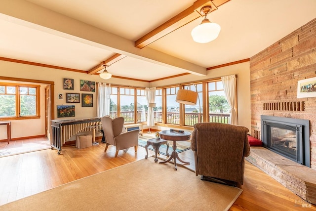 living room with a fireplace, beam ceiling, wood finished floors, and baseboards