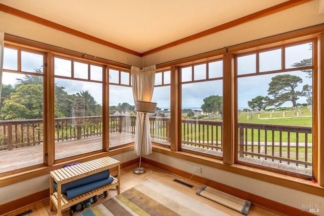 sunroom / solarium featuring visible vents, wood finished floors, and a wealth of natural light