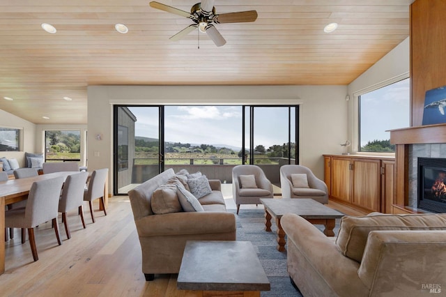 living area with light wood-style floors, ceiling fan, vaulted ceiling, and wood ceiling
