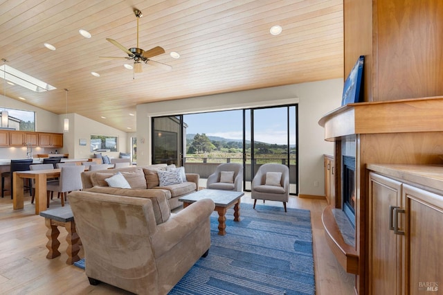 living room with light wood finished floors, recessed lighting, a fireplace, ceiling fan, and a mountain view