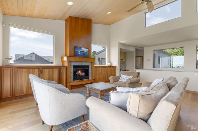 living area with recessed lighting, a large fireplace, wooden ceiling, light wood-type flooring, and a ceiling fan