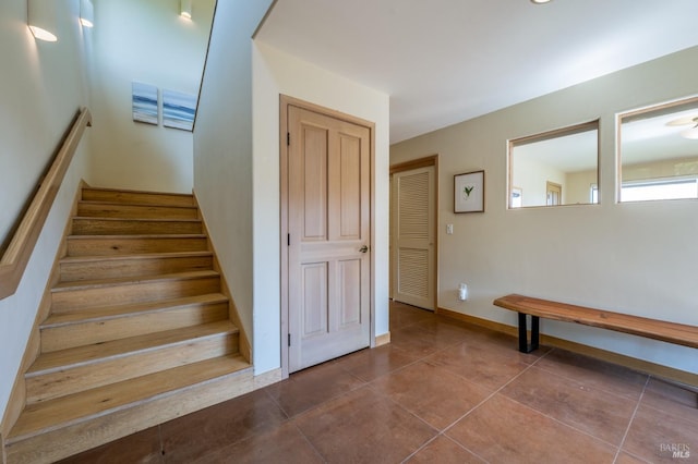 staircase with tile patterned floors and baseboards