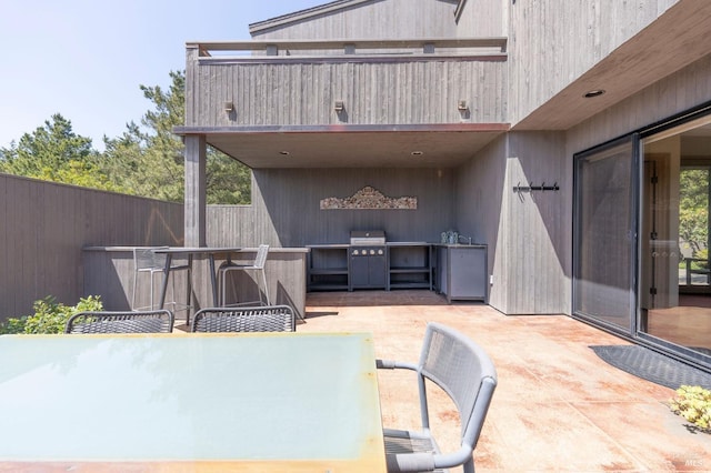 view of patio with area for grilling, outdoor dining space, and fence