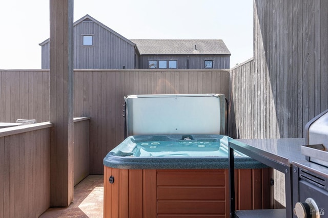 view of patio with fence and a hot tub