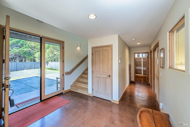 doorway to outside featuring dark tile patterned floors, recessed lighting, and stairs