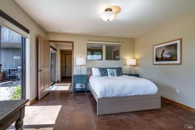bedroom with dark tile patterned flooring, baseboards, and multiple windows