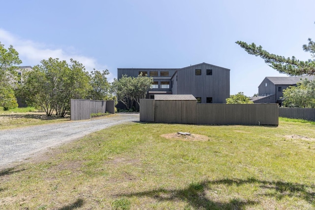 view of yard featuring driveway and fence