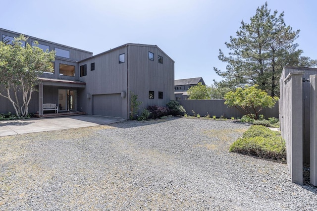 view of side of home with driveway and fence