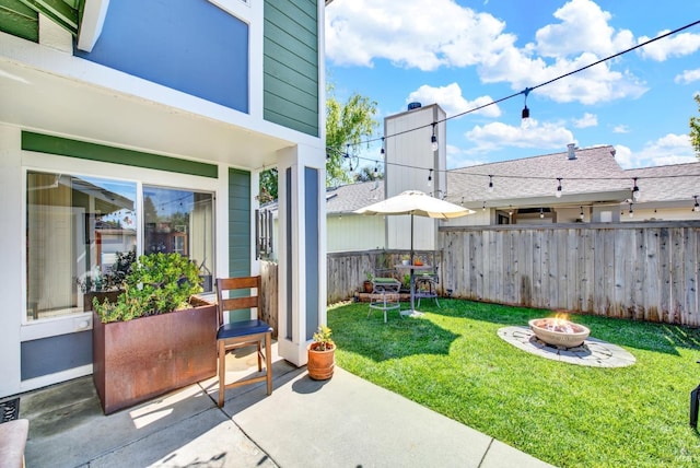 view of yard with an outdoor fire pit, a patio, visible vents, and fence