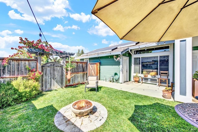 view of yard with an outdoor fire pit, fence, and a patio